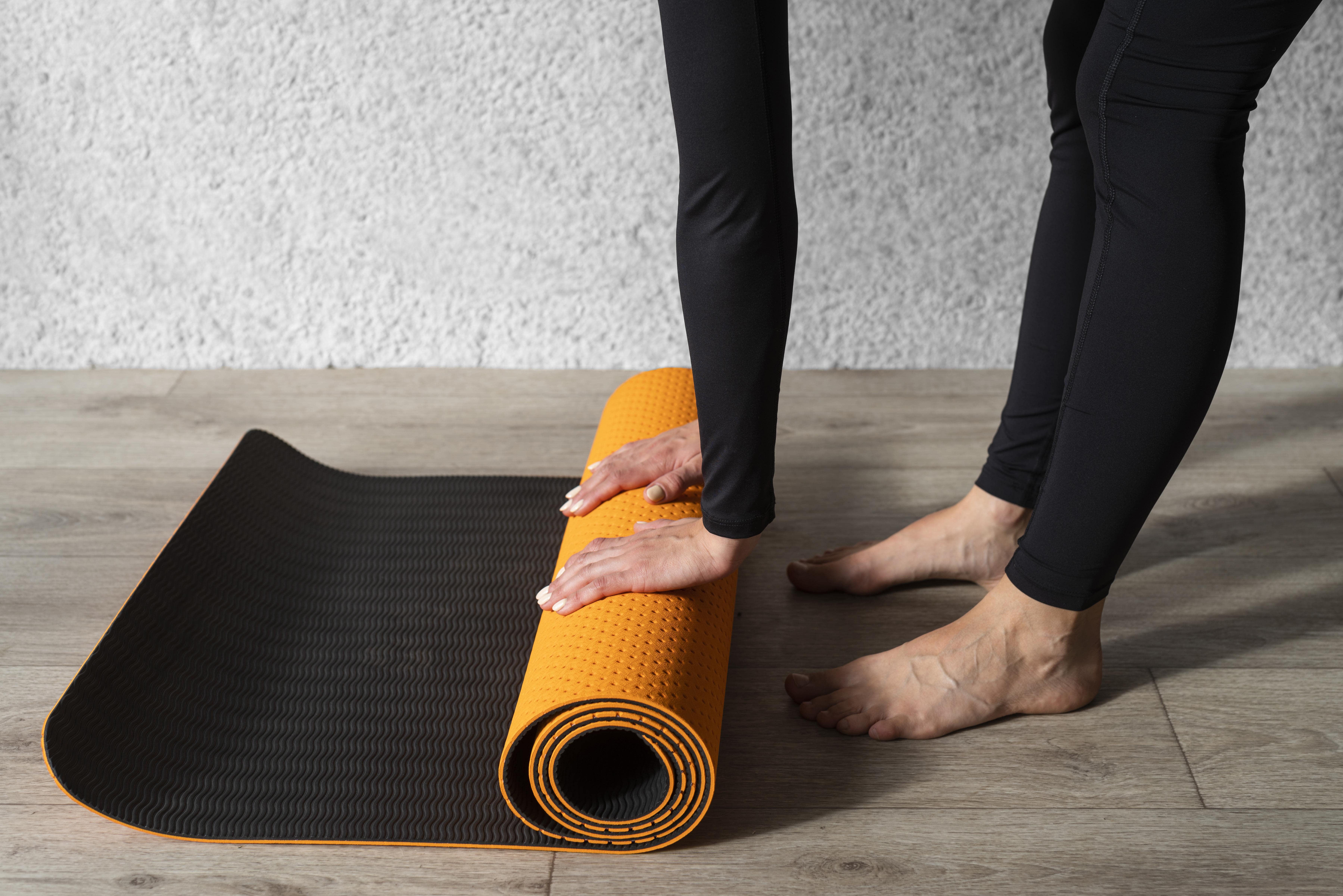  close-up-hands-touching-yoga-mat-min
