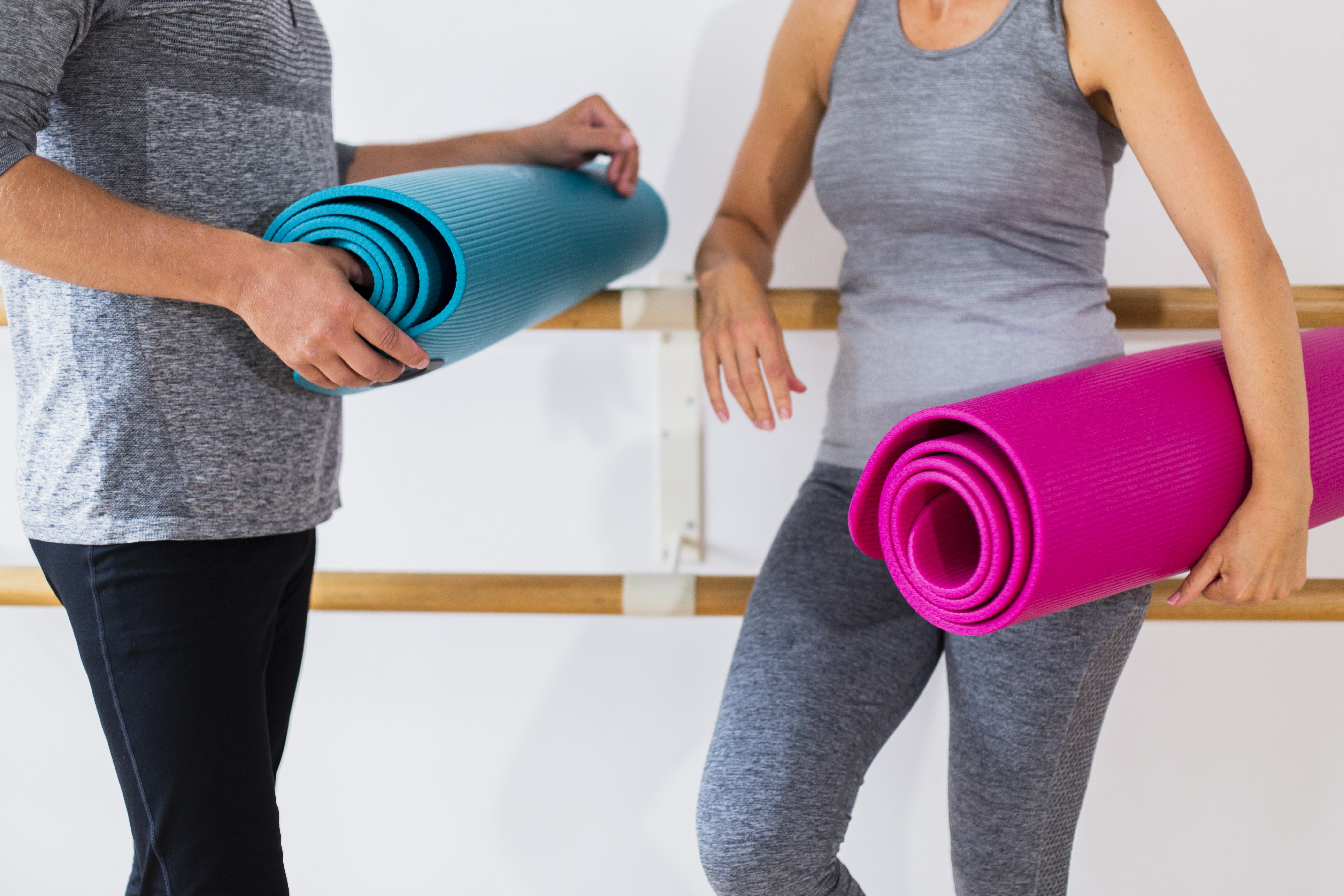  senior-man-woman-holding-yoga-mats-min