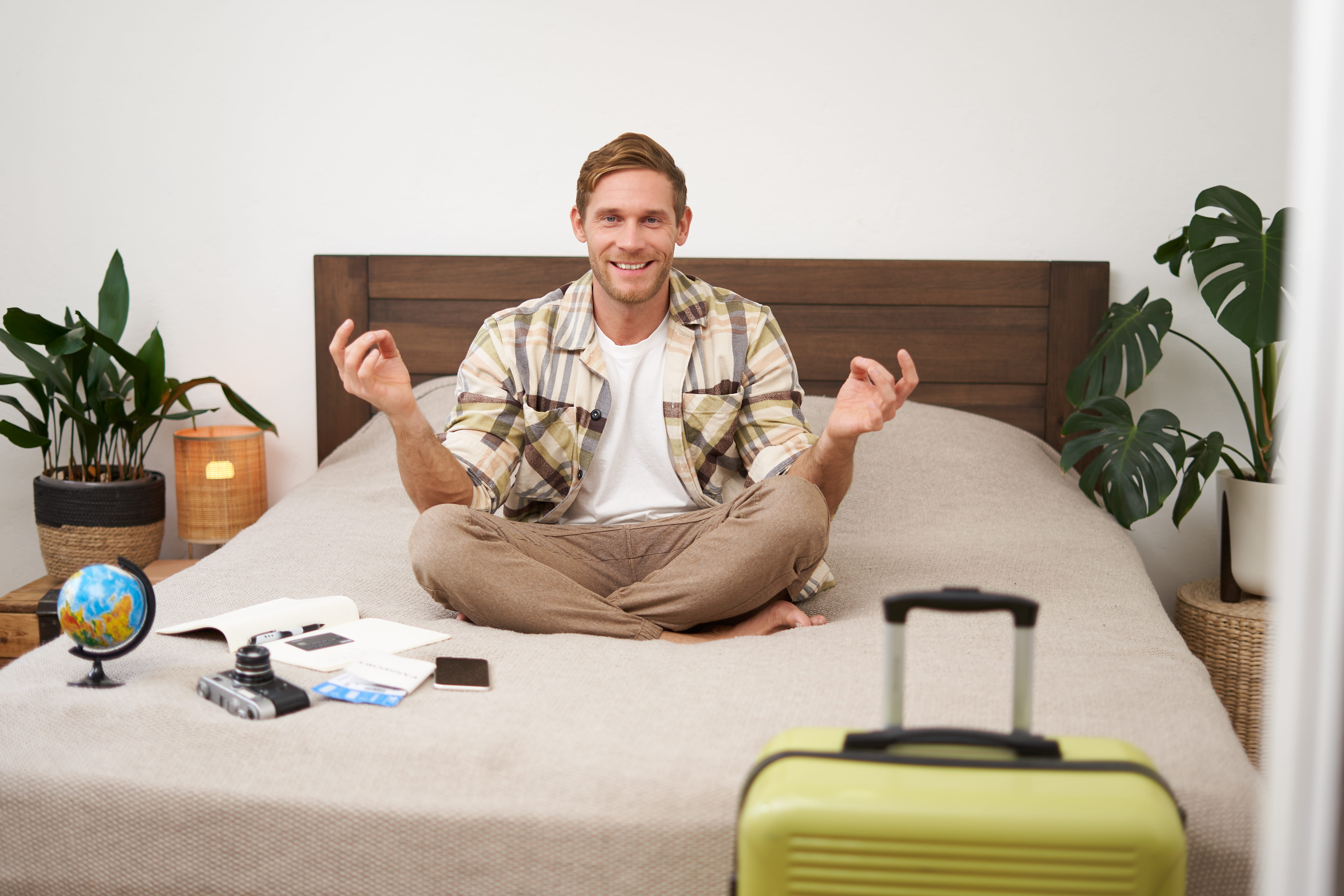  portrait-young-man-meditating-packing-suitcase-sitting-bed-with-globe-camera-plane-tickets_1